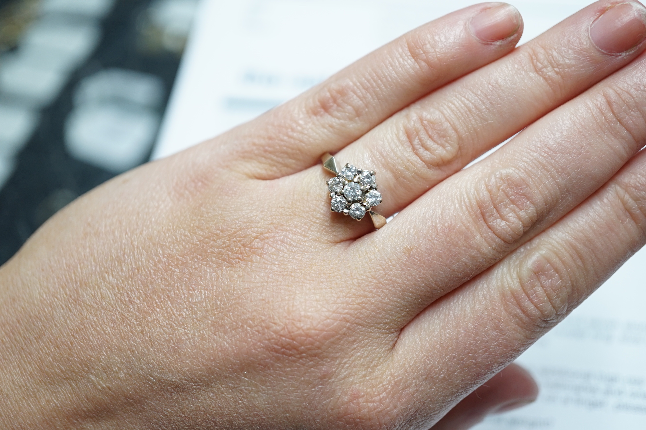 A modern 18ct white gold and seven stone diamond set hexagonal cluster ring, size O, gross weight 3.9 grams.
